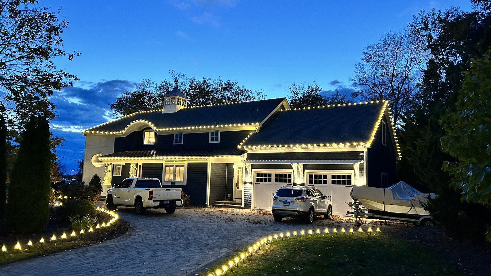 A home and street beautifully lit for Christmas at night